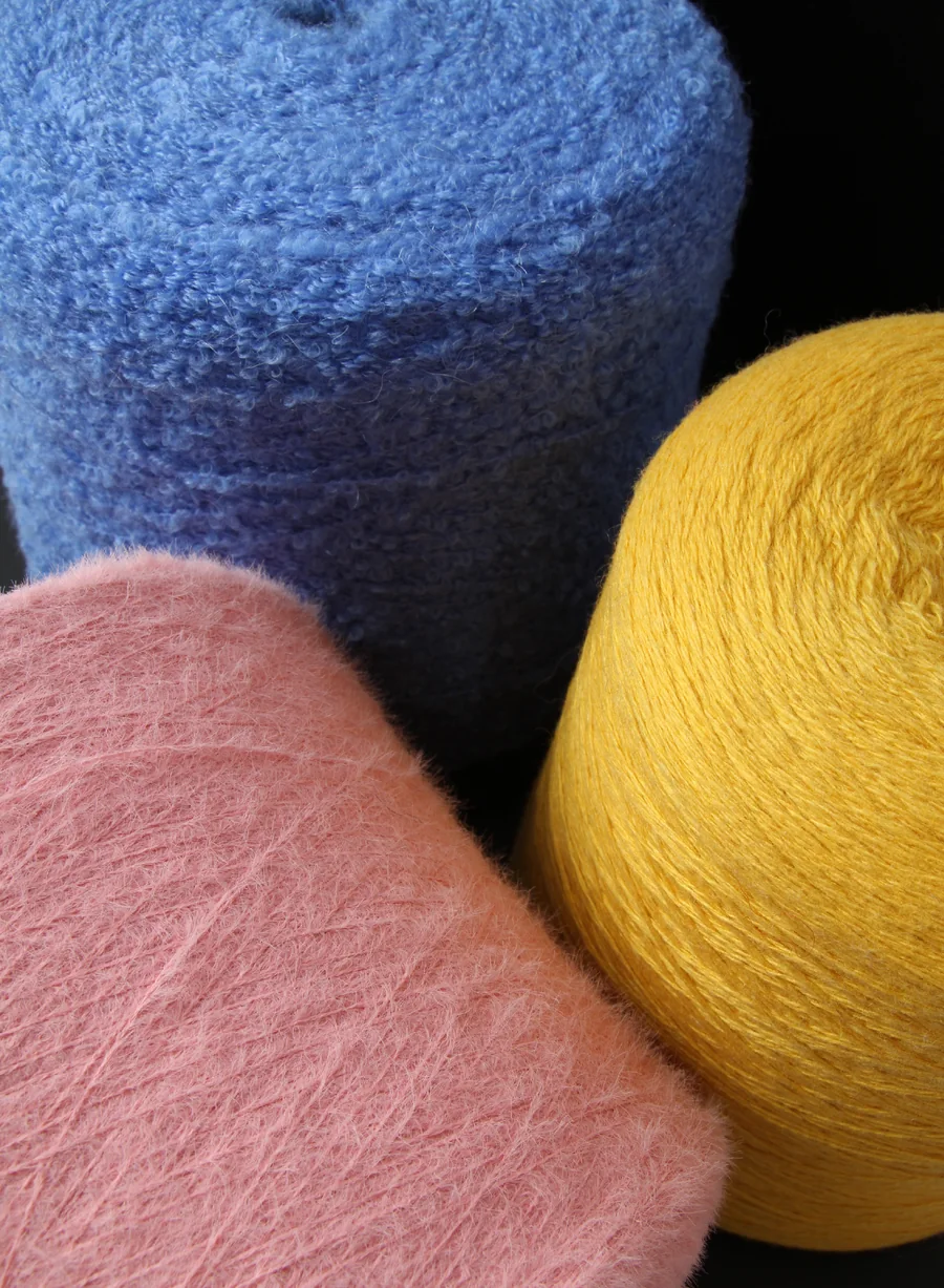Blue, pink and yellow fuzzy yarn cones in a client-supplied photograph